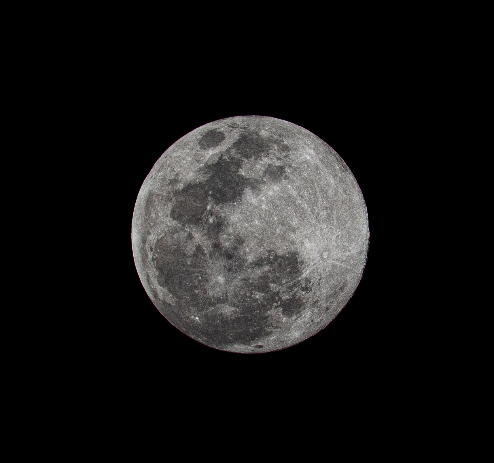 A detailed full moon isolated against a deep black sky