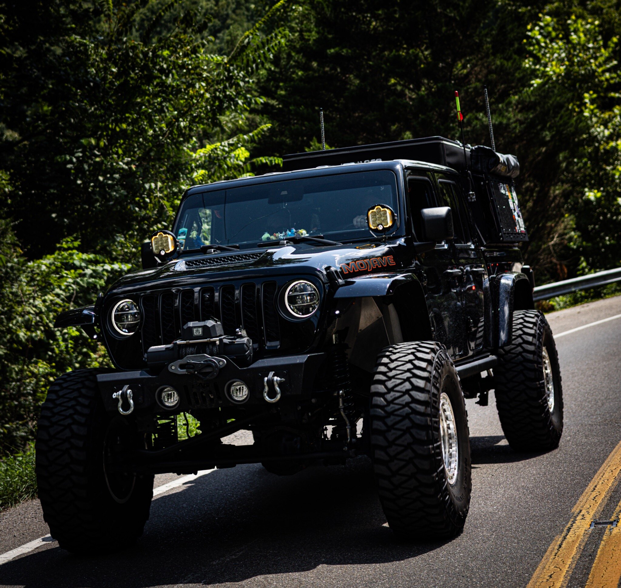 A black Jeep Gladiator Mojave overland build rolling through the mountains